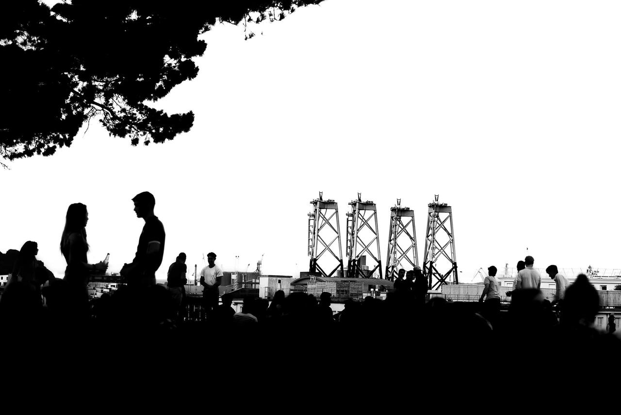 Un groupe de persoonnes en ombres chinoises devant le port de Brest
