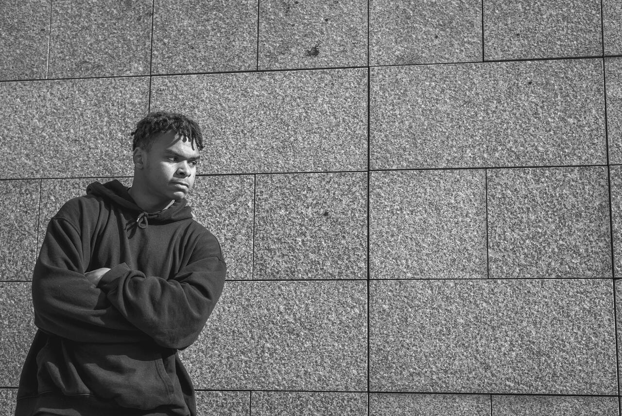 Un homme est  adossé au mur