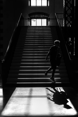 Un enfant joue dans l'ombre en bas des escaliers