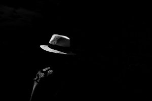Photographie de rue par Damien Goret - un homme dans l'ombre, on voit seulement son chapeau grace à un trait de lumière